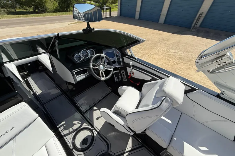 Slide: The Image of 2020 MasterCraft XT25 boat interior with sleek dashboard and white seating. - 11