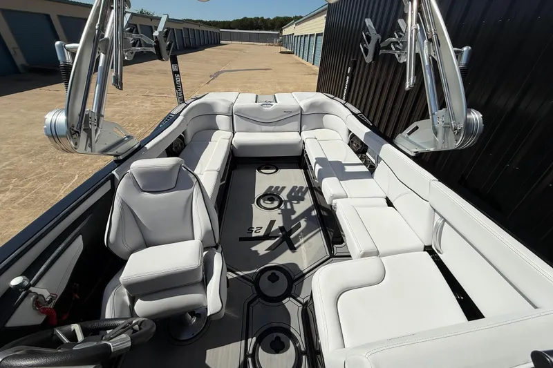 Slide: The Image of 2020 MasterCraft XT25 boat interior with white seating and modern design. - 14
