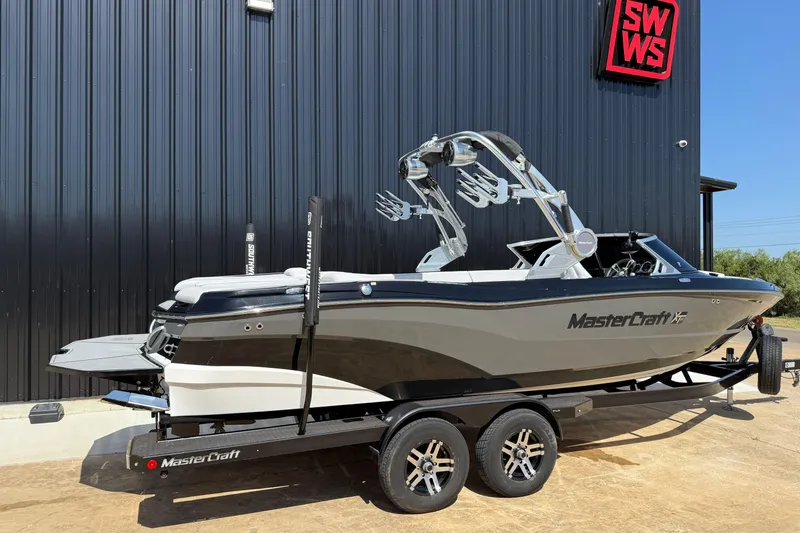 Slide: The Image of 2020 MasterCraft XT25 boat on trailer, parked outside a building. - 4