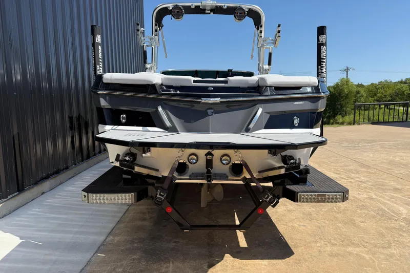 Slide: The Image of 2020 MasterCraft XT25 boat rear view, parked outdoors on concrete surface. - 6