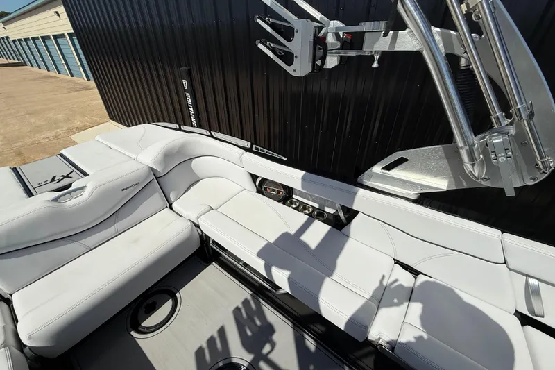 Slide: The Image of 2020 MasterCraft XT25 boat interior with white seating and metal fixtures. - 8