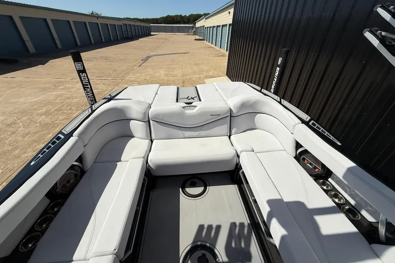 Slide: The Image of 2020 MasterCraft XT25 boat interior with white seating, docked near storage units. - 9