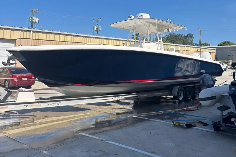 Slide: The Image of 2005 Venture boat on trailer, being cleaned at a marina, sunny day. - 18