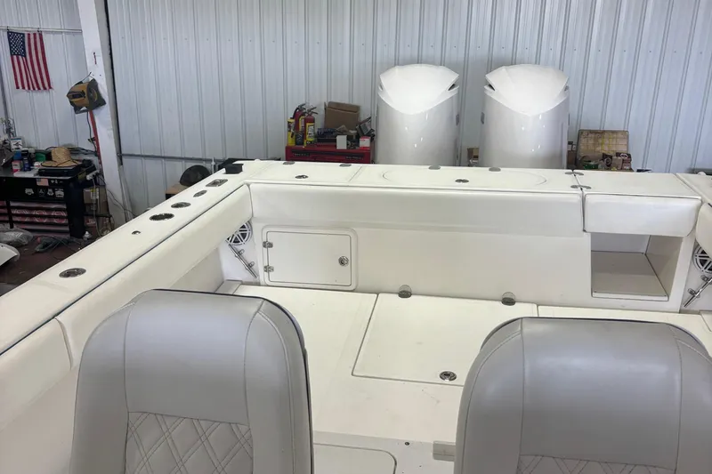Slide: The Image of Interior of a 2005 Venture boat with white seating and storage compartments. - 27