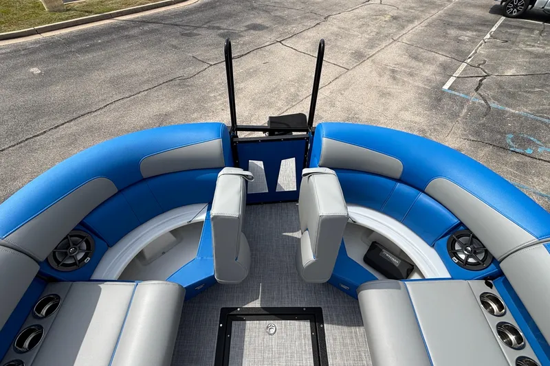 Slide: The Image of 2025 Montara 25 Surf Boss boat interior with blue and gray seating, speakers, and cup holders. - 10
