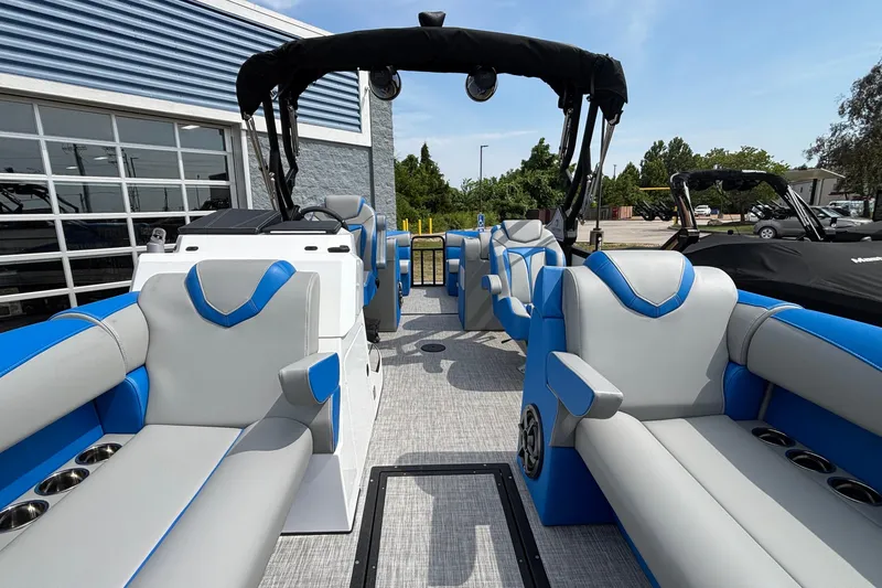 Slide: The Image of 2025 Montara 25 Surf Boss boat interior with blue and gray seating, docked outdoors. - 15