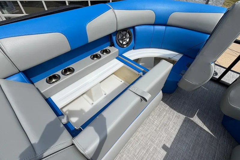 Slide: The Image of 2025 Montara 25 Surf Boss boat interior with blue and gray seating, cup holders, and speaker. - 17