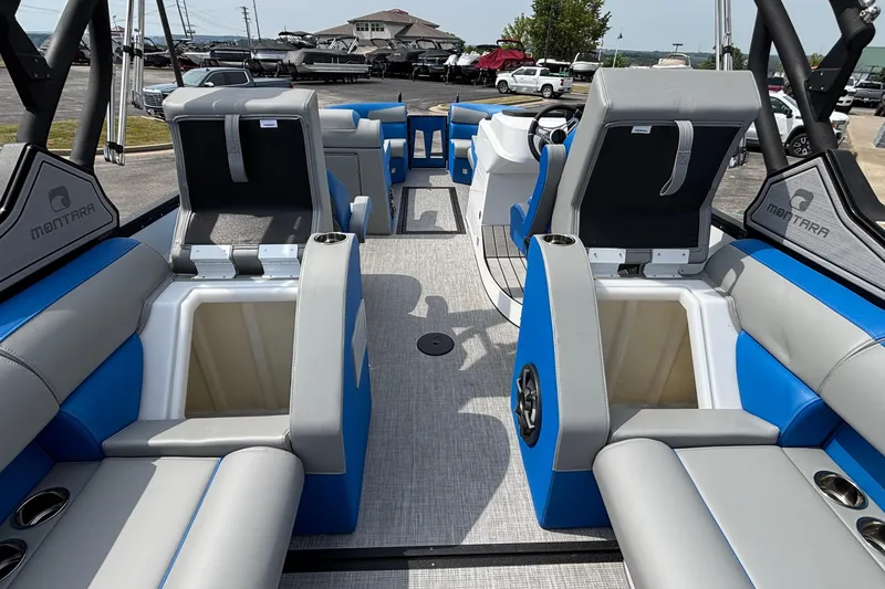 Slide: The Image of 2025 Montara 25 Surf Boss interior with blue and gray seating, cup holders, and storage compartments. - 18