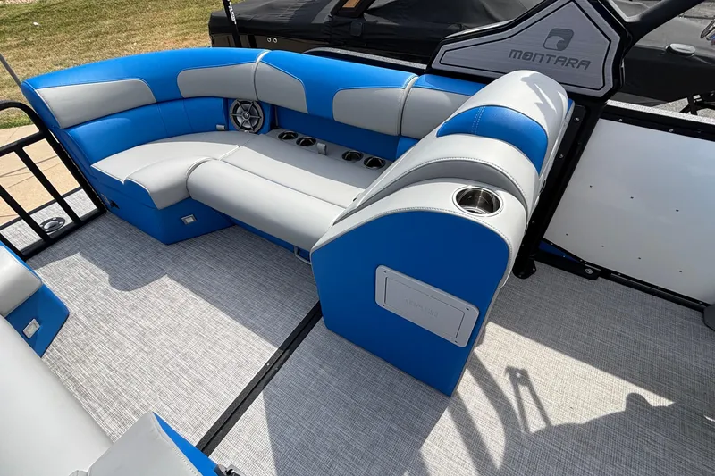 Slide: The Image of 2025 Montara 25 Surf Boss interior with blue and gray seating, cup holders, and speaker. - 21