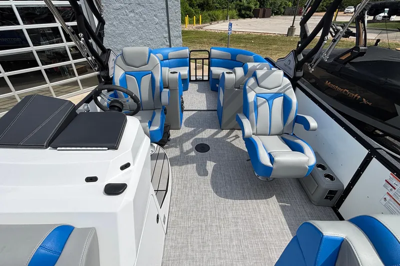 Slide: The Image of 2025 Montara 25 Surf Boss boat interior with blue and gray seating, steering wheel, and modern design. - 22
