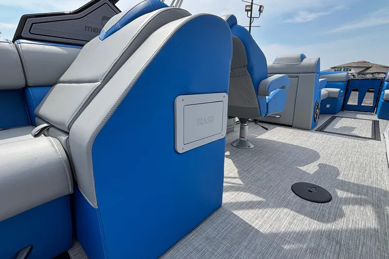 Slide: The Image of 2025 Montara 25 Surf Boss interior with blue and gray seating, trash compartment, and modern design. - 25