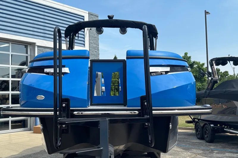 Slide: The Image of 2025 Montara 25 Surf Boss boat, blue exterior, displayed outdoors near a building. - 3