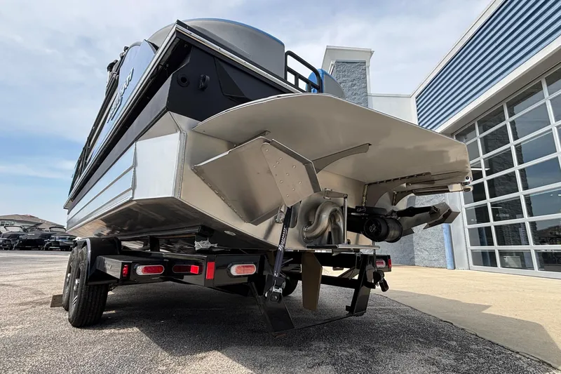 Slide: The Image of 2025 Montara 25 Surf Boss boat on trailer, rear view, outside a modern building. - 31