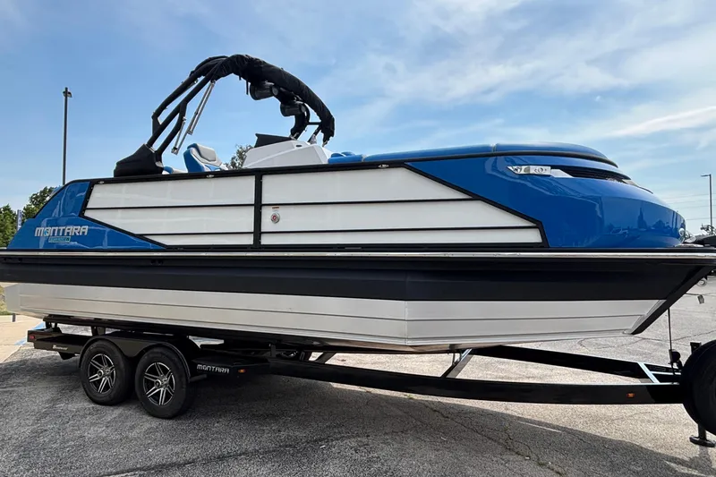 Slide: The Image of 2025 Montara 25 Surf Boss boat on trailer, blue and white design. - 4