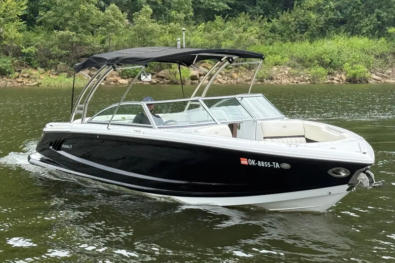 Slide: The Image of 2013 Cobalt A28 boat cruising on a lake with lush green shoreline. - 15