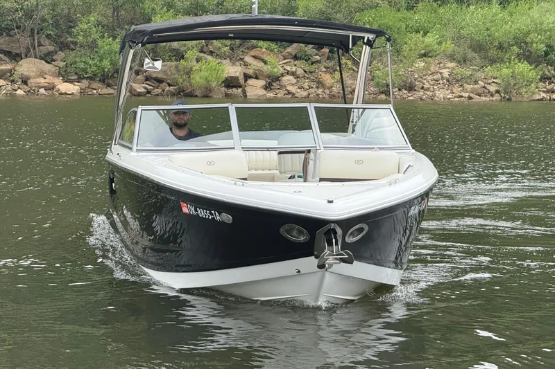 Slide: The Image of 2013 Cobalt A28 boat cruising on a calm lake near a rocky shoreline. - 17