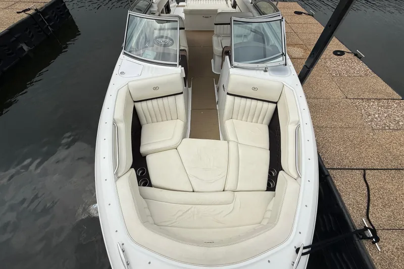 Slide: The Image of 2013 Cobalt A28 boat with spacious white seating, docked by the water. - 24