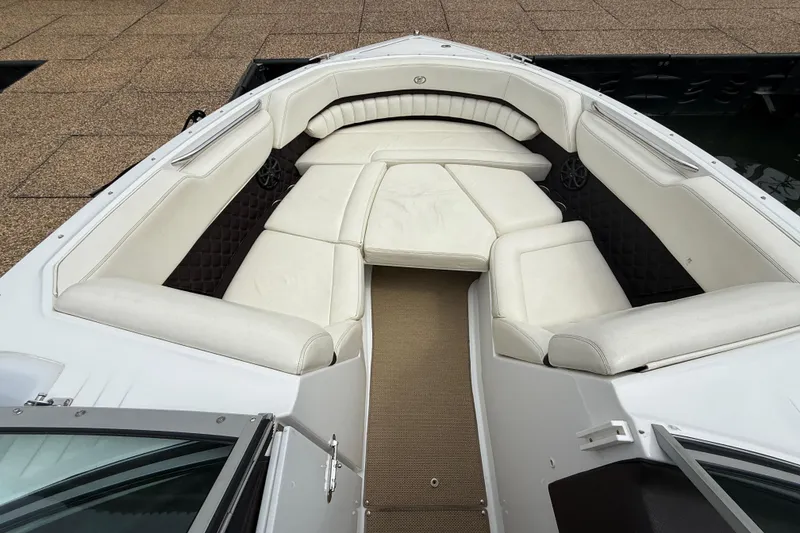 Slide: The Image of 2013 Cobalt A28 boat interior with white cushioned seating and carpeted floor. - 26