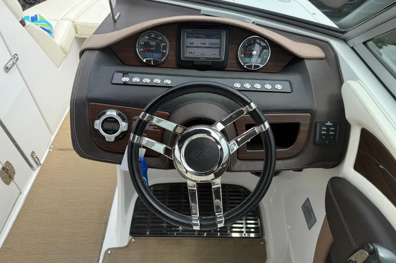 Slide: The Image of Steering wheel and dashboard of 2013 Cobalt A28 boat, featuring modern controls and gauges. - 30