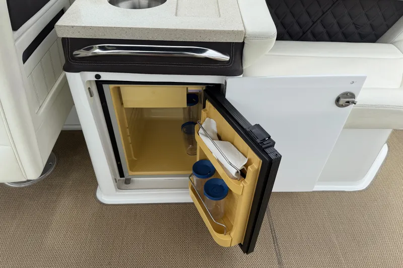 Slide: The Image of 2013 Cobalt A28 boat interior with open mini fridge and countertop. - 31