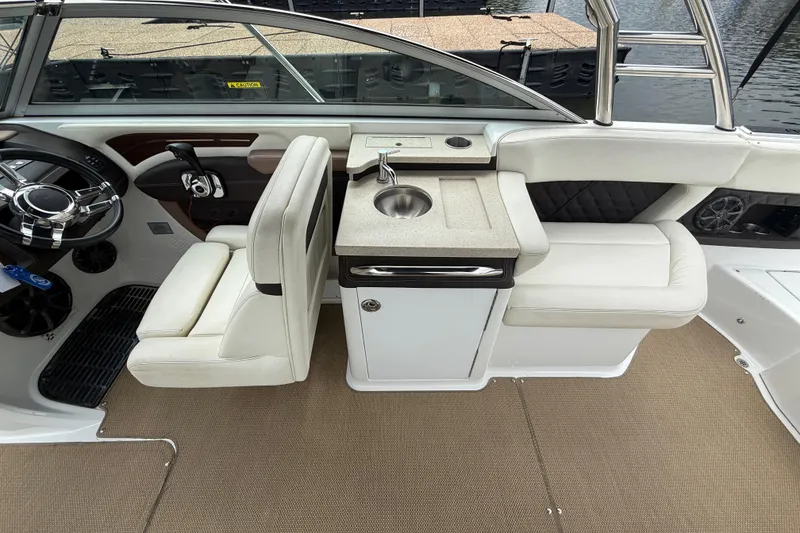 Slide: The Image of Interior of 2013 Cobalt A28 boat with steering wheel, sink, and seating. - 32
