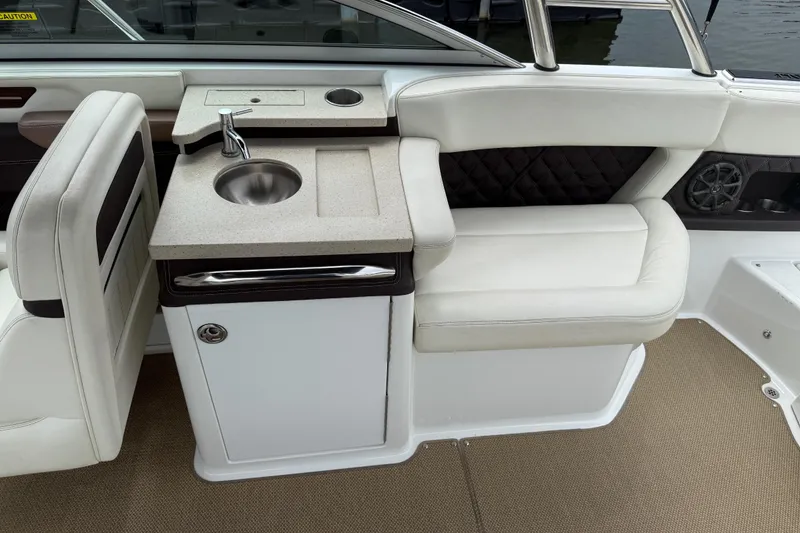 Slide: The Image of 2013 Cobalt A28 boat interior with sink, cushioned seating, and modern design. - 33