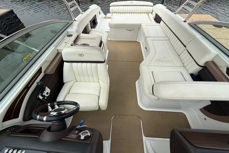 Slide: The Image of 2013 Cobalt A28 boat interior with white leather seating and modern steering wheel. - 34