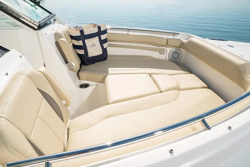 Slide: The Image of Manufacturer Provided Image: 2025 Pursuit DC 266 Dual Console boat interior with beige seating and nautical bag. - 13