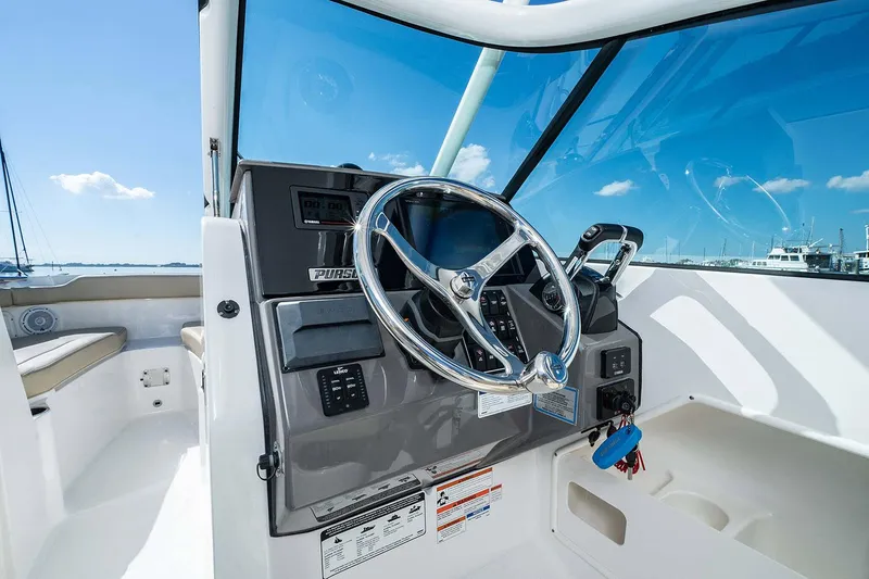 Slide: The Image of Manufacturer Provided Image: 2025 Pursuit DC 266 Dual Console boat helm with steering wheel and controls. - 15