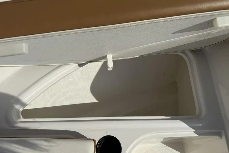 Slide: The Image of Open storage compartment in 2020 Bayliner VR4 Bowrider boat, featuring white interior and brown trim. - 10