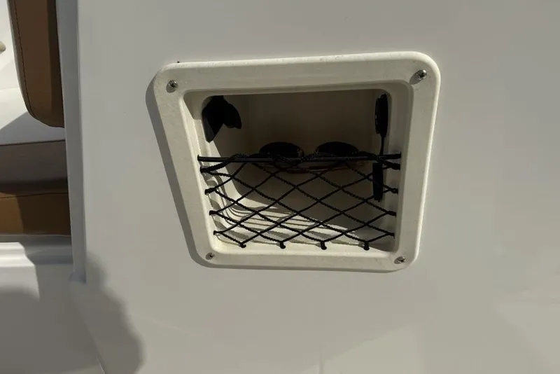 Slide: The Image of 2020 Bayliner VR4 Bowrider storage compartment with netting on white surface. - 13