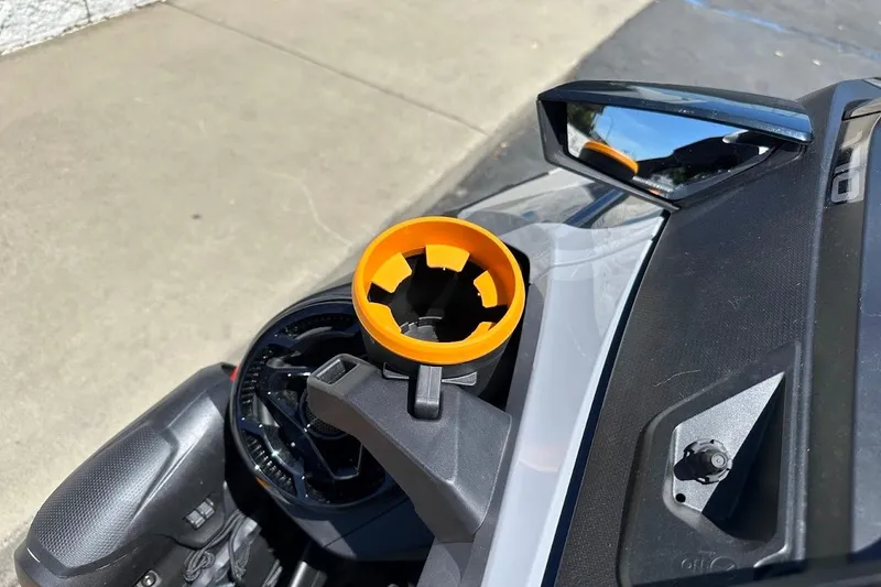 Slide: The Image of 2023 Sea-Doo Fish Pro Trophy dashboard with orange cup holder and side mirror. - 11