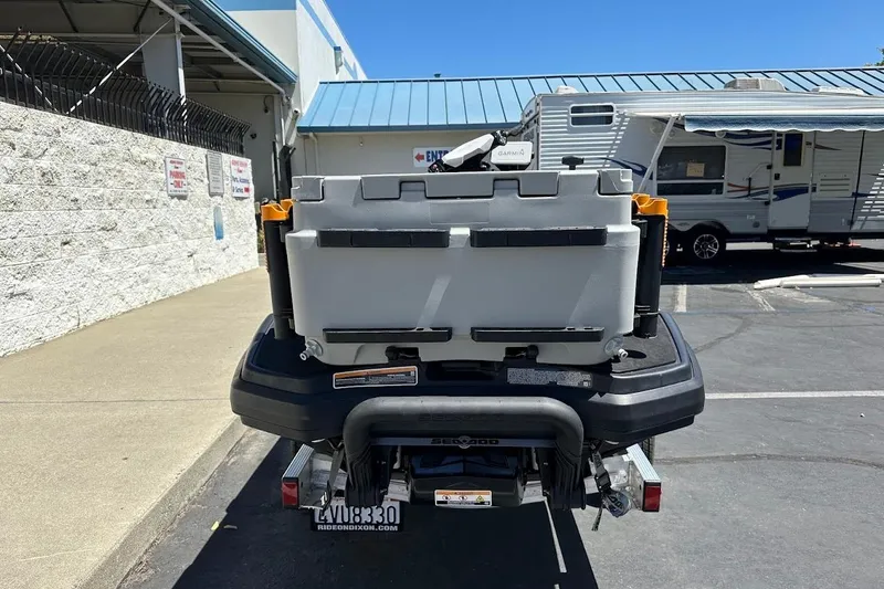 Slide: The Image of 2023 Sea-Doo Fish Pro Trophy with storage box, parked near RV and building. - 5