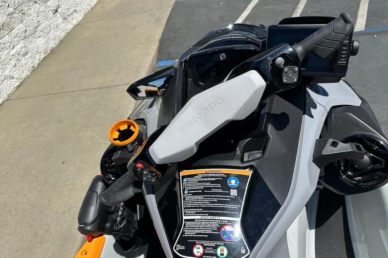 Slide: The Image of 2023 Sea-Doo Fish Pro Trophy dashboard with controls and display, parked on pavement. - 8