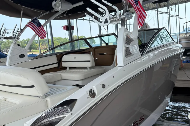 Slide: The Image of 2016 Cobalt R5 WSS Surf boat with American flags, docked in a marina. - 23