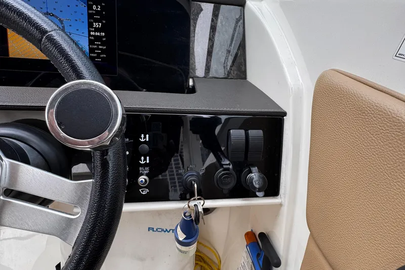 Slide: The Image of Steering wheel and control panel of a 2020 Sea Ray boat, featuring navigation display. - 13