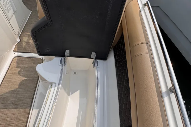 Slide: The Image of 2020 Sea Ray boat storage compartment with open lid, beige seating, and textured flooring. - 16