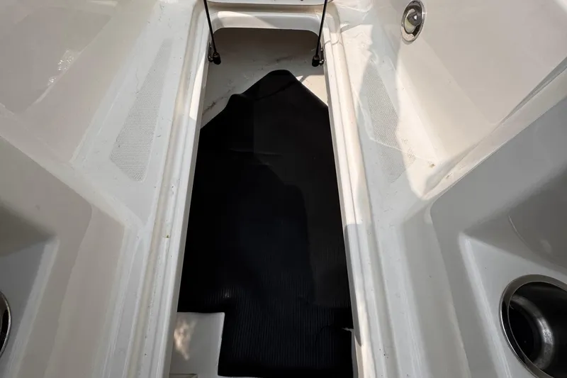 Slide: The Image of 2020 Sea Ray boat interior storage compartment with black mat and cup holders. - 17