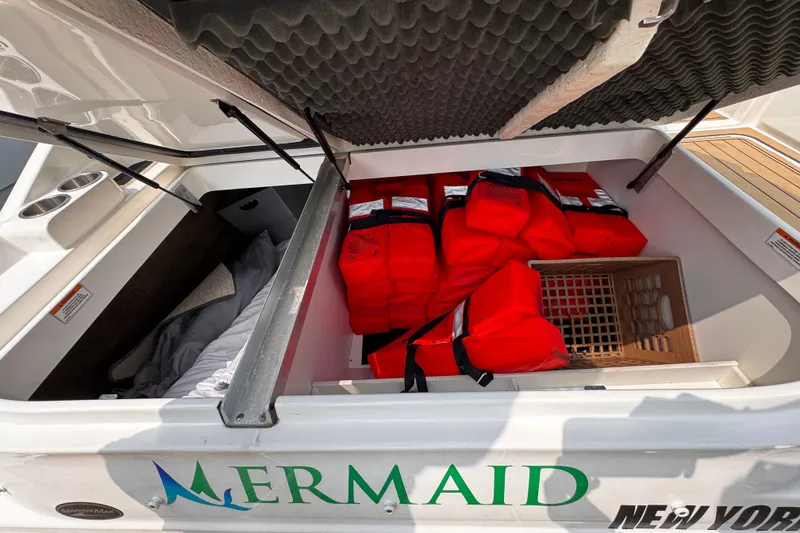 Slide: The Image of Open storage compartment on 2020 Sea Ray boat with life jackets and bedding. - 19