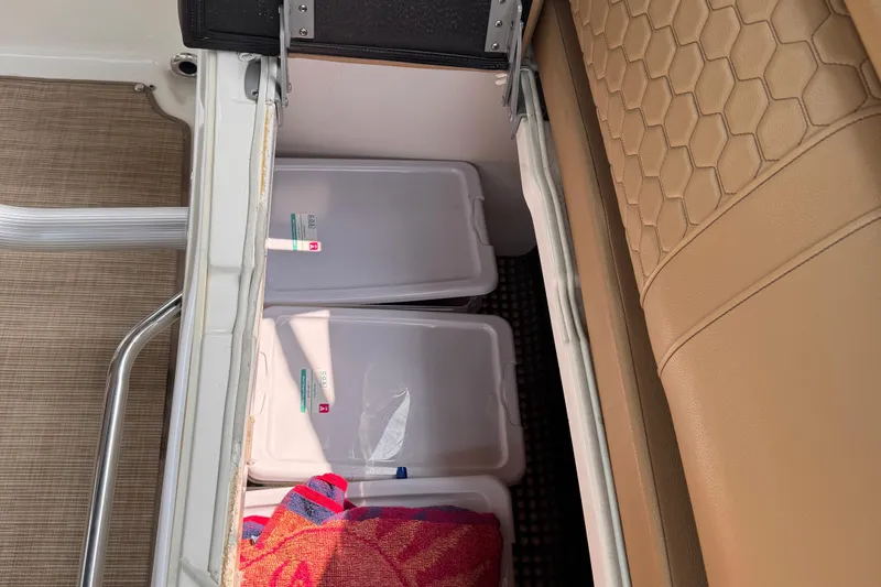 Slide: The Image of Storage compartment on a 2020 Sea Ray boat with containers and a towel. - 27