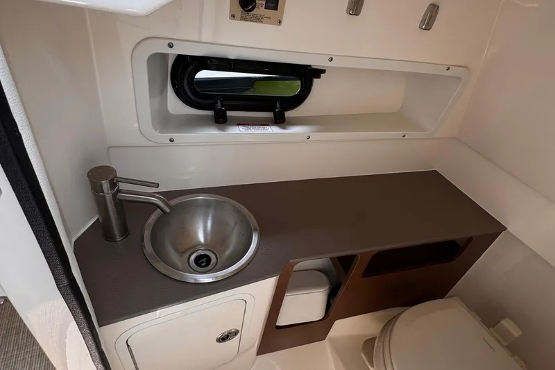Slide: The Image of 2020 Sea Ray boat bathroom with stainless steel sink and compact toilet. - 30