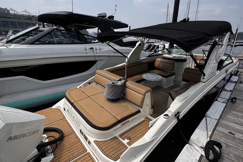 Slide: The Image of 2020 Sea Ray boat with tan seating and black canopy docked at marina. - 6
