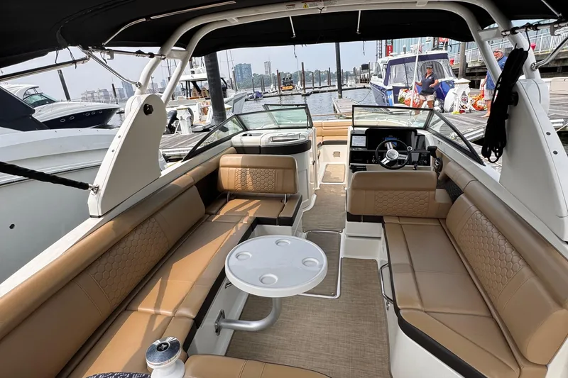 Slide: The Image of Luxurious 2020 Sea Ray boat interior with tan seating and modern dashboard at a marina. - 8