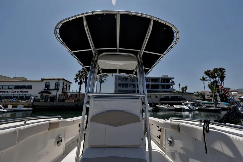 Slide: The Image of 2016 Robalo R222 Center Console boat docked at marina, featuring T-top and seating. - 15