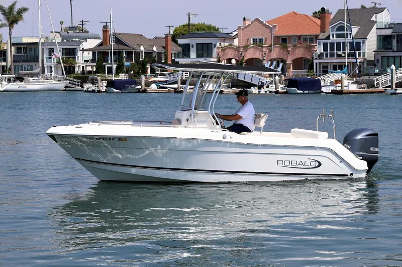 Slide: The Image of 2016 Robalo R222 Center Console boat cruising in a scenic waterfront area. - 3