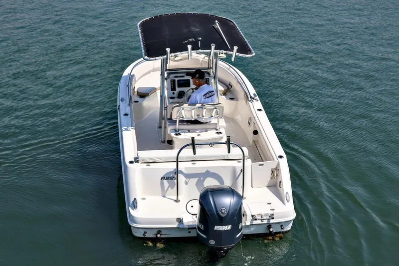 Slide: The Image of 2016 Robalo R222 Center Console boat on water, rear view with canopy and outboard motor. - 5