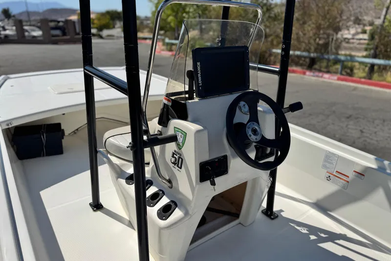 Slide: The Image of 2017 Mako Pro Skiff 17 CC boat console with steering wheel and navigation equipment. - 13