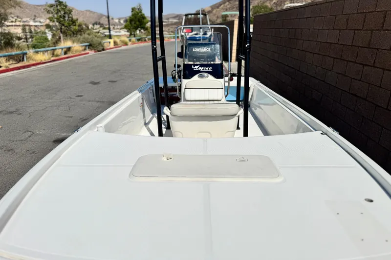 Slide: The Image of 2017 Mako Pro Skiff 17 CC boat on a paved road, featuring a central console. - 7