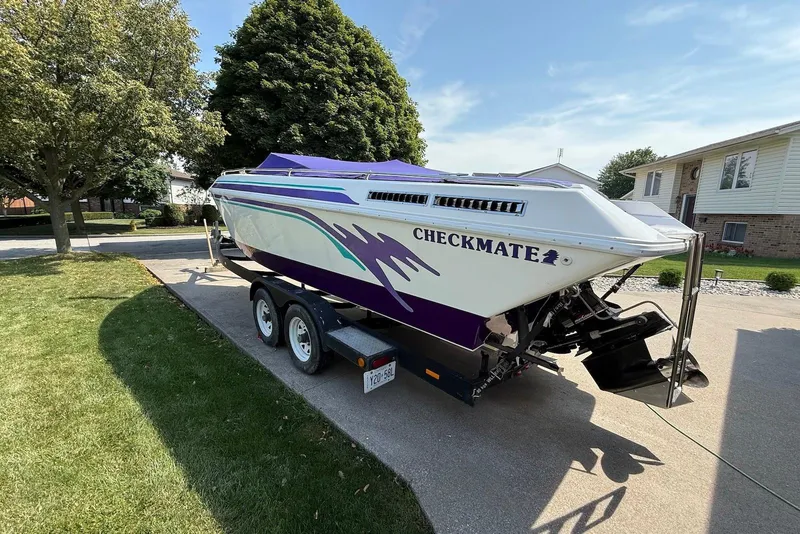Slide: The Image of 1995 Checkmate Persuader 261 boat on trailer, parked in residential driveway. - 10