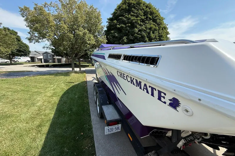 Slide: The Image of 1995 Checkmate Persuader 261 boat on trailer, parked in a residential area. - 11